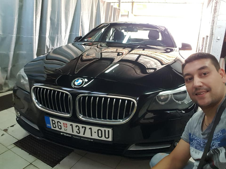 Covek i crni automobil BMW